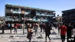 Palestinians walk in the courtyard of a school after an Israeli airstrike hit the site, in Nuseirat in the central Gaza Strip, Sept. 11, 2024