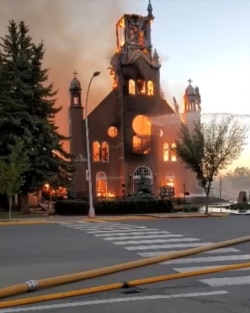 FILE - Flames engulf a Catholic Church as firefighters work to extinguish the fire at St. Jean Baptiste Parish in Morinville, Alberta, Canada, June 30, 2021, in this still image taken from video obtained from social media. (Diane Burrel /via Reuters)