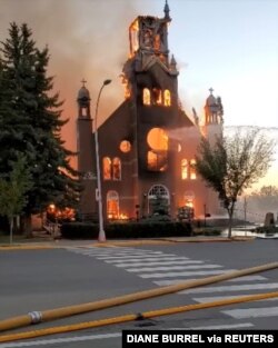 FILE - Flames engulf a Catholic Church as firefighters work to extinguish the fire at St. Jean Baptiste Parish in Morinville, Alberta, Canada, June 30, 2021, in this still image taken from video obtained from social media. (Diane Burrel /via Reuters)