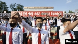 FILE - North Korean youth and students wearing protective face masks hold a rally condemning leaflets launched by defectors in South Korea with messages critical of Kim Jong Un's regime, in Pyongyang, North Korea, June 6, 2020. (Kyodo via Reuters)