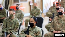 FILE - U.S. soldiers wearing protective masks are seen during a handover ceremony of Taji military base from US-led coalition troops to Iraqi security forces, in the base north of Baghdad, Iraq Aug. 23, 2020. 