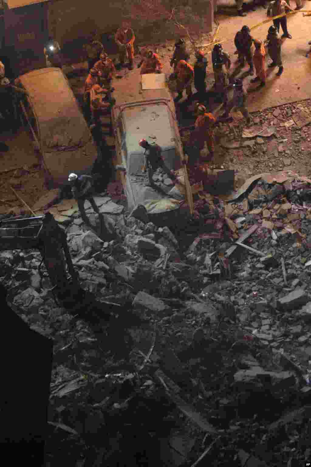 Rescue crew work among debris of a collapsed building in Rio de Janeiro. January 25, 2012. (Reuters)