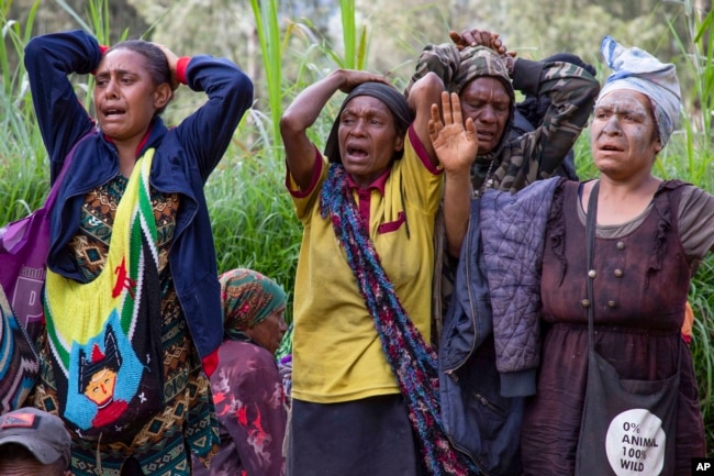 In this photo released by UNDP Papua New Guinea, villagers react as they search through a landslide in Yambali village, in the Highlands of Papua New Guinea, Monday, May 27, 2024. (Juho Valta/UNDP Papua New Guinea via AP)