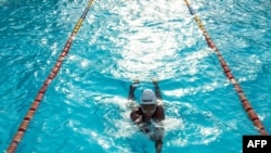 Ugandan Husnah Kukundakwe, 16, swims during a training session at Elite swim and gym center in Kampala on December 19, 2023, ahead of the 2024 Paris Paralympic games.