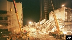 Rescuers work by floodlight at the wreckage of the destroyed Ufundi House in Nairobi, Kenya on Aug. 9, 1998, next to the American embassy building at left.