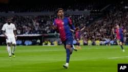 Barcelona's Lamine Yamal gestures after scoring his side's third goal during a Spanish La Liga match between Real Madrid and Barcelona at the Santiago Bernabeu stadium in Madrid, Spain, Oct. 26, 2024.