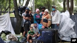Una familia de migrantes venezolanos es vista cerca de una estación de autobuses en Bogotá, Colombia, el 10 de junio de 2020.