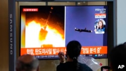 People watch a TV showing a file image of North Korea's missiles launch during a news program at the Seoul Railway Station in Seoul, South Korea, Sept. 28, 2021.