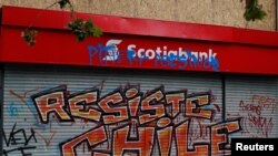 FILE - A Scotiabank gate is seen graffitied during a protest against Chile's government in Santiago, Chile, Nov. 1, 2019.