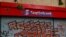 FILE - A Scotiabank gate is seen graffitied during a protest against Chile's government in Santiago, Chile, Nov. 1, 2019.