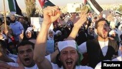 Jordanians and Syrian refugees protest the killing of at least 108 people in the Syrian town of Houla last Friday, outside the Syrian embassy in Amman, Jordan, May 30, 2012. 