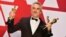 FILE - Alfonso Cuaron poses with the awards for best director for "Roma," best foreign language film for "Roma," and best cinematography for "Roma" in the press room at the Oscars at the Dolby Theatre in Los Angeles, Feb. 24, 2019.