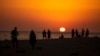 ARCHIVO: Personas observan el atardecer en una playa cerca del faro de Trafalgar, el 29 de julio de 2020, en Los Caños de Meca, España. 