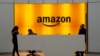 FILE - In this Feb. 14, 2019, file photo people stand in the lobby for Amazon offices in New York.