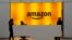 FILE - In this Feb. 14, 2019, file photo people stand in the lobby for Amazon offices in New York.