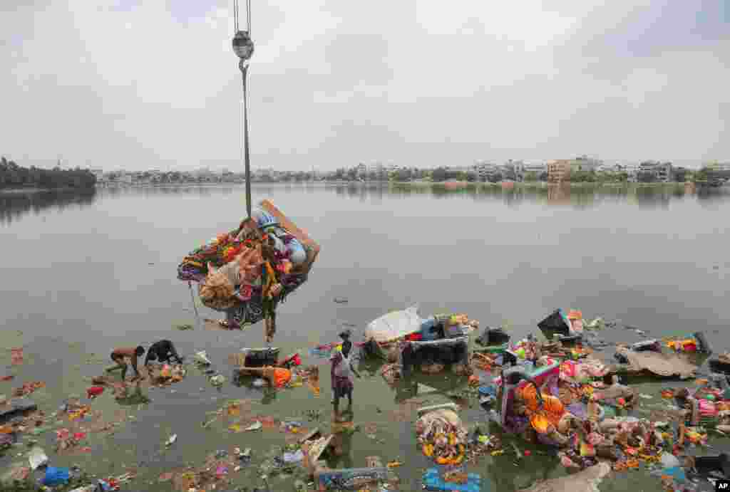 Workers remove idols of elephant-headed Hindu god Ganesha that were immersed in Saroornagar Lake on the final day of the Ganesh Chaturthi festival in Hyderabad, India.
