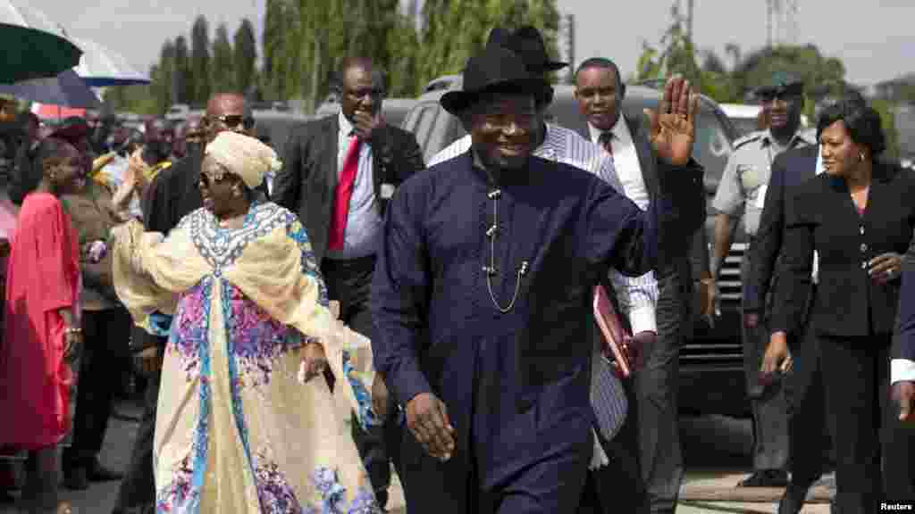 Le président Goodluck Jonathan du Nigeria (C) et sa femme saluent de la main des électeurs en file, attentant de voter à Otuoke, dans l&#39;État de Bayelsa, le 28 mars 2015.