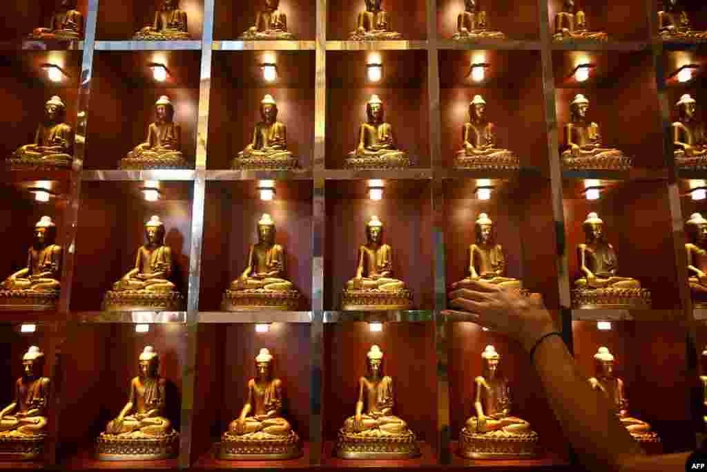 A man arranges Buddha statues in preparation for the upcoming Lunar New Year of the Snake at Vihara Buddhayana in Surabaya.