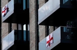 English flags fly from balconies near Wembley stadium in London, July 9, 2021.