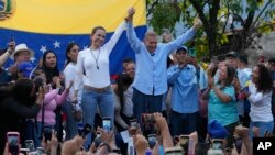 FILE - Venezuelan opposition leader Mariana Corina Machado, center-left, and then-presidential candidate Edmundo Gonzalez Urrutia, acknowledge supporters during a campaign rally in Guatire, Venezuela, May 31, 2024.
