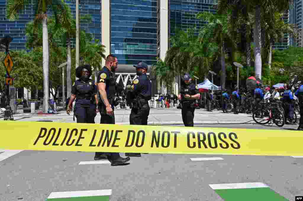 Los oficiales de policía limpian un área para examinar un objeto encontrado frente al Palacio de Justicia de los Estados Unidos Wilkie D. Ferguson Jr. antes de la lectura de cargos del expresidente Donald Trump.