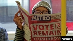 Seorang wanita membaca surat kabar di kereta bawah tanah di Inggris dengan iklan ‘pilih untuk tetap bergabung’ terkait dengan referendum Brexit. London, Inggris. (Foto: REUTERS/Russell Boyce)