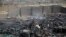 FILE - Workers salvage oil canisters from the wreckage of a vehicle oil store hit by Saudi-led airstrikes in Sanaa, Yemen, July 2, 2020.