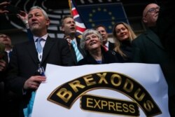 British MEPs, or Member of the European Parliament, celebrate as they march out of European Parliament with their luggage in Brussels to take the Eurostar train back to Britain, Jan. 31, 2020, the day the U.K. is due to leave the EU.