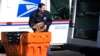 FILE - A US Postal Service employee loads parcels outside a post office in Wheeling, Ill., on Jan. 29, 2024. 