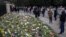 People look at flowers outside Windsor Castle in Windsor, England, to pay tribute to Britain's Prince Philip, the irascible and tough-minded husband of Queen Elizabeth II, April 11, 2021.