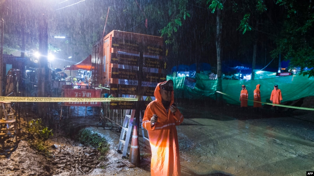 A Thai policeman guards an area under rainfall near the Tham Luang cave at the Khun Nam Nang Non Forest Park in Mae Sai district of Chiang Rai province, July 7, 2018, as rescue operation continues for the 12 boys and their football team coach.