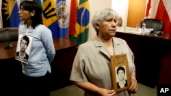 Raida Condor, right, and Carmen Amaro, relatives of Amador Condor, killed during the government of Peru's former President Alberto Fujimori, hold a portrait of him, inside the chambers of the Inter-American Court of Human Rights where judges are analyzing arguments against a presidential pardon of Peru's former President Alberto Fujimori, in San Jose, Costa Rica, Feb. 2, 2018.