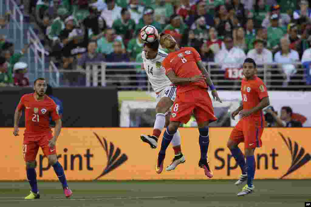 &nbsp; Dan wasan Mexico, Javier Hernandez, na biyu daga hagu da Arturo Vidal na kasar Chile (mai sanye da riga mai lamba 8) su na kokawar neman kwallo a lokacin karawar tasu.