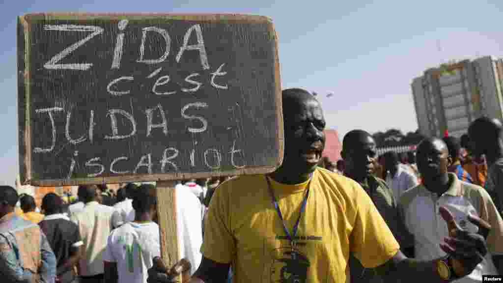 A protester carries a sign reading "Zida is Judas Iscariot," referring to coup leader Lt. Col. Yacouba Isaac Zida, in Ouagadougou, capital of Burkina Faso, Nov. 2, 2014. 