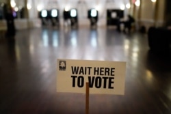 FILE - A sign is displayed for voters to guide the way at a precinct during Georgia's Senate runoff elections on Jan. 5, 2021, in Atlanta.