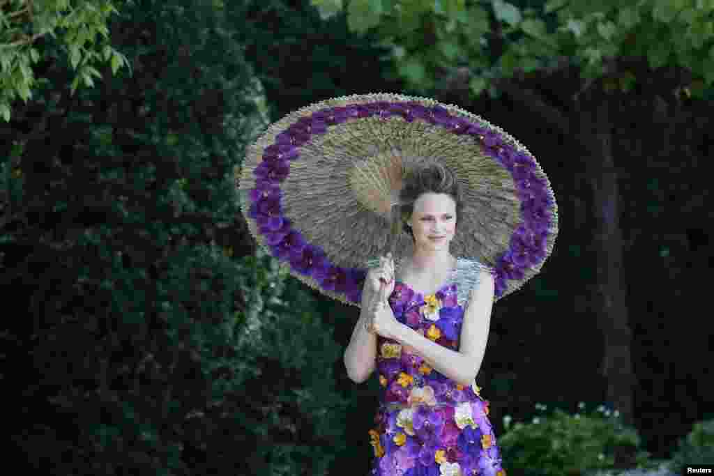 A model wearing a dress made of 1,000 Orchida Vanda petals, designed by Judith Blacklock, poses for photographers in the M &amp; A Garden during media day at the Chelsea Flower Show in London.