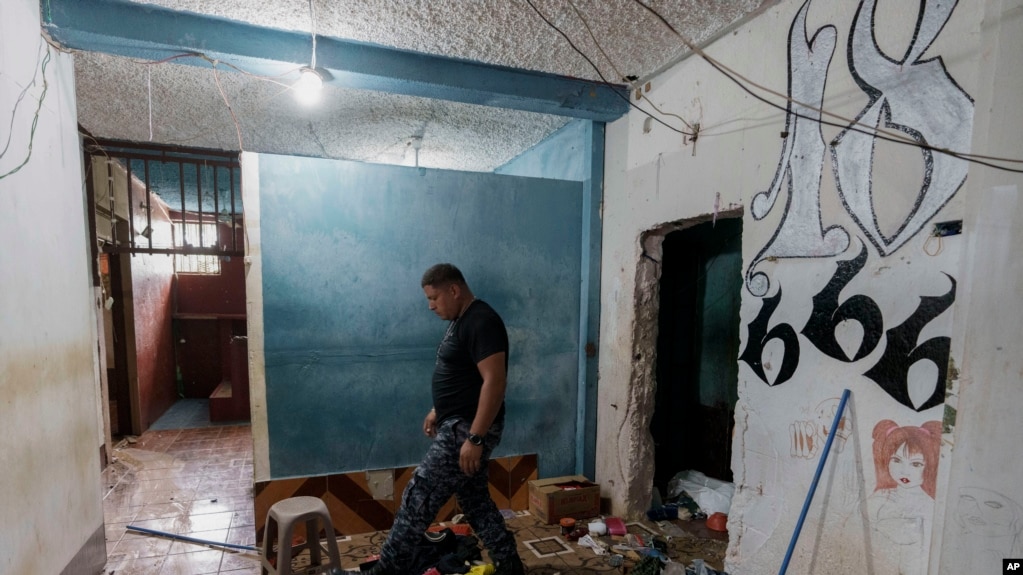 Un guardia camina junto al grafiti de la pandilla Barrio 18 dentro de la prisión de alta seguridad El Infiernito en Escuintla, Guatemala, el domingo 2 de junio de 2024. (AP Foto/Moisés Castillo)