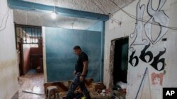 Un guardia camina junto al grafiti de la pandilla Barrio 18 dentro de la prisión de alta seguridad El Infiernito en Escuintla, Guatemala, el domingo 2 de junio de 2024. (AP Foto/Moisés Castillo)