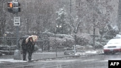 Pedestrians weather the latest storm to hit the US east coast 