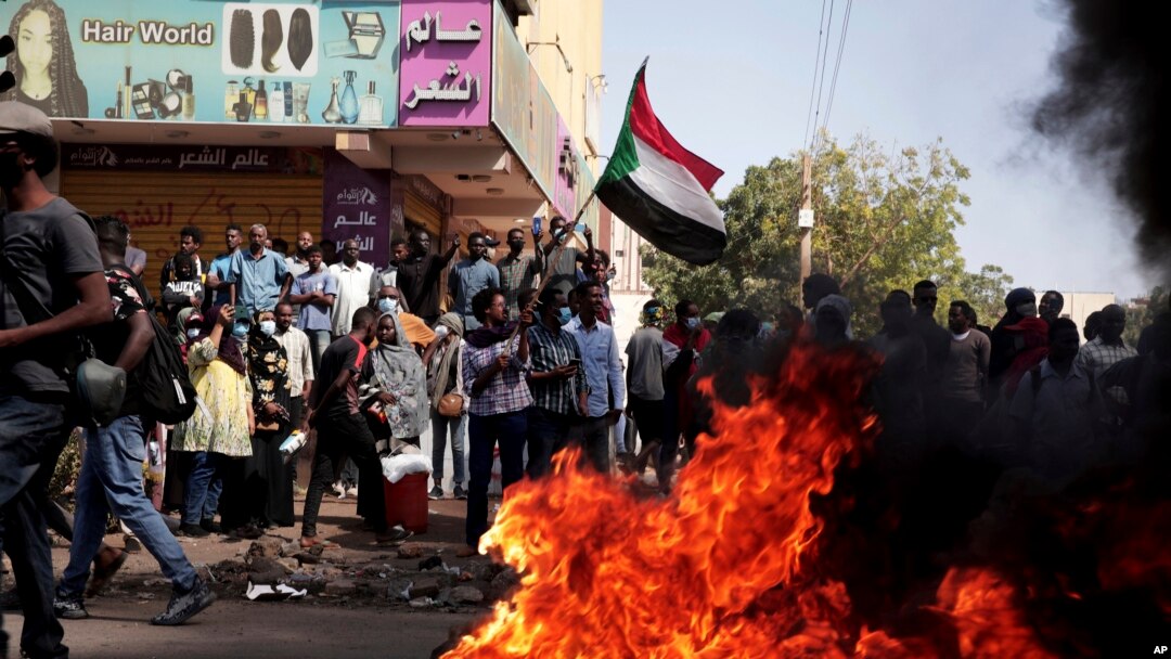 FILE: People chant slogans and burn tires during a protest to denounce the October 2021 military coup, in Khartoum, Sudan, Jan. 6, 2022.