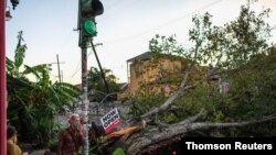 Olivia Mancing (izq.) y Zachery Quale conversan cerca de un árbol caído en la calle, después de que el huracán Zeta azotara Nueva Orleans, Louisiana, EE. UU., el 29 de octubre de 2020.