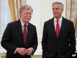 FILE - White House national security adviser John Bolton, left, and U.S. Ambassador to Russia Jon Huntsman wait to begin talks with Russian President Vladimir Putin in the Kremlin in Moscow, June 27, 2018.