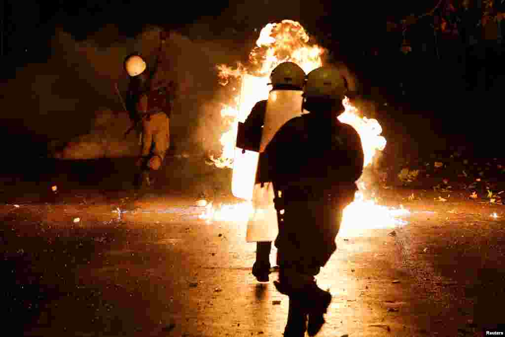 A petrol bomb explodes among riot policemen during clashes following a rally marking the 44th anniversary of a 1973 student uprising against the military dictatorship that was ruling Greece, in Athens.