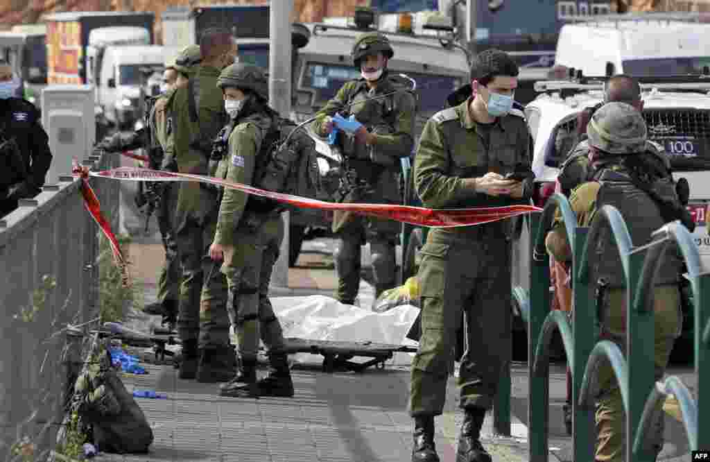 Israeli soldiers gather by the body of a Palestinian man who was shot dead reportedly while attempting a knife attack at the Gitai Avisar Junction, west of the Jewish settlement of Ariel and south of Nablus in the occupied West Bank.