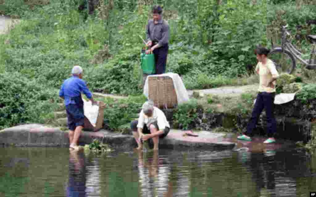 几位村民在池塘边洗菜