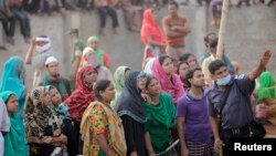 A police officer shows the rubble of the collapsed Rana Plaza building to locals in Savar, 30 km (19 miles) outside Dhaka, April 26, 2013. 