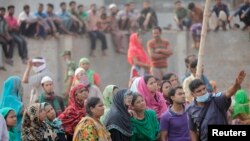 Seorang polisi tengah menunjukkan puing-puing runtuh Rana gedung Plaza kepada penduduk setempat di Savar, 30 kilometer di luar Dhaka (26/4).