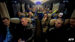 Para tahanan perang Ukraina berada di dalam bus setelah pertukaran tahanan di lokasi yang tidak disebutkan di tengah invasi Rusia ke Ukraina, 30 Desember 2024. Rusia dan Ukraina melakukan pertukaranan 300 tahanan perang. (Foto: Telegram Presiden Ukraina Volodymyr Zelensky/AFP)