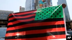 FILE - A man holds an African-American flag at a rally in Chicago on June 19, 2020, to mark Juneteenth, the the day in 1865 that enslaved black people in Galveston, Texas, learned they had been freed from bondage, more than two years after the Emancipation Proclamation.