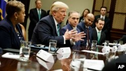 President Donald Trump, accompanied by Veterans Affairs Secretary David Shulkin, speaks during a meeting about veterans affairs, March 17, 2017, in the Roosevelt Room of the White House in Washington.